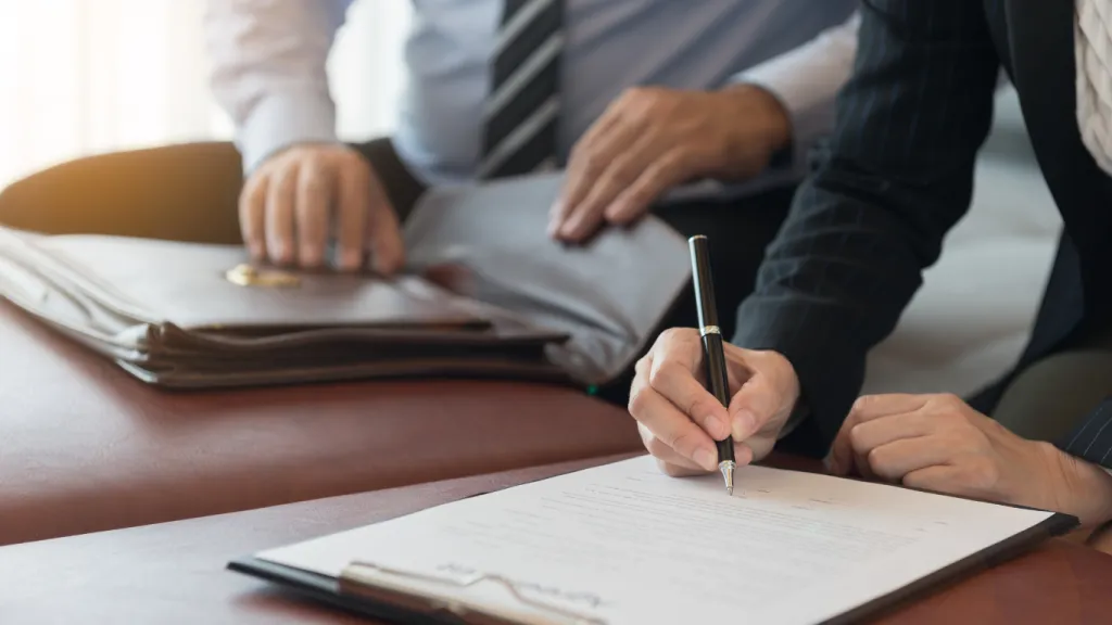 A person signing documents in an international bank, emphasizing the process of opening offshore accounts.