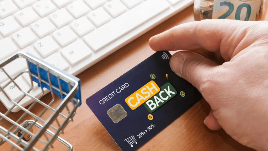 A hand holding a credit card with cashback benefits, highlighting online shopping perks and financial rewards.