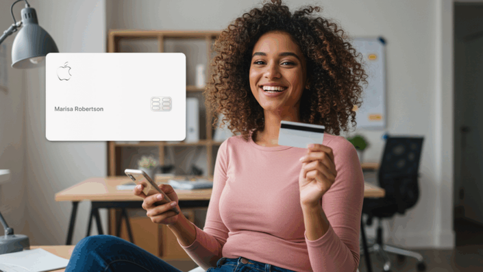 Happy woman with curly hair sitting in a home office, holding a smartphone and a credit card. On the left, an Apple Card with the name Marisa Robertson is shown.