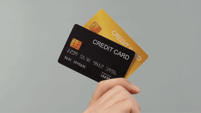 Dos tarjetas de crédito, una azul y una dorada, dispuestas una sobre la otra, representando las herramientas financieras que impactan el Puntaje de crédito.