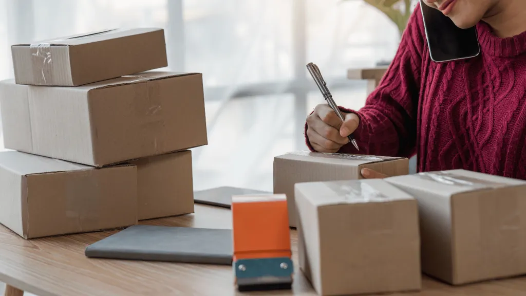 A business owner preparing packages for shipment, representing a successful dropshipping business to make money online.