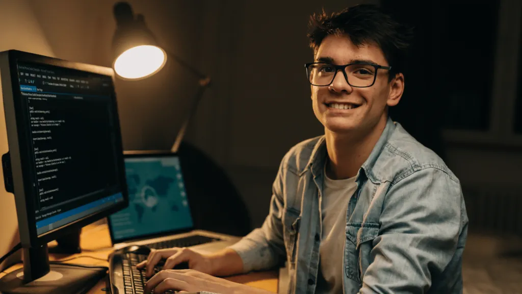 A smiling freelancer coding on a computer, showcasing how professionals can make money online through remote tech jobs.