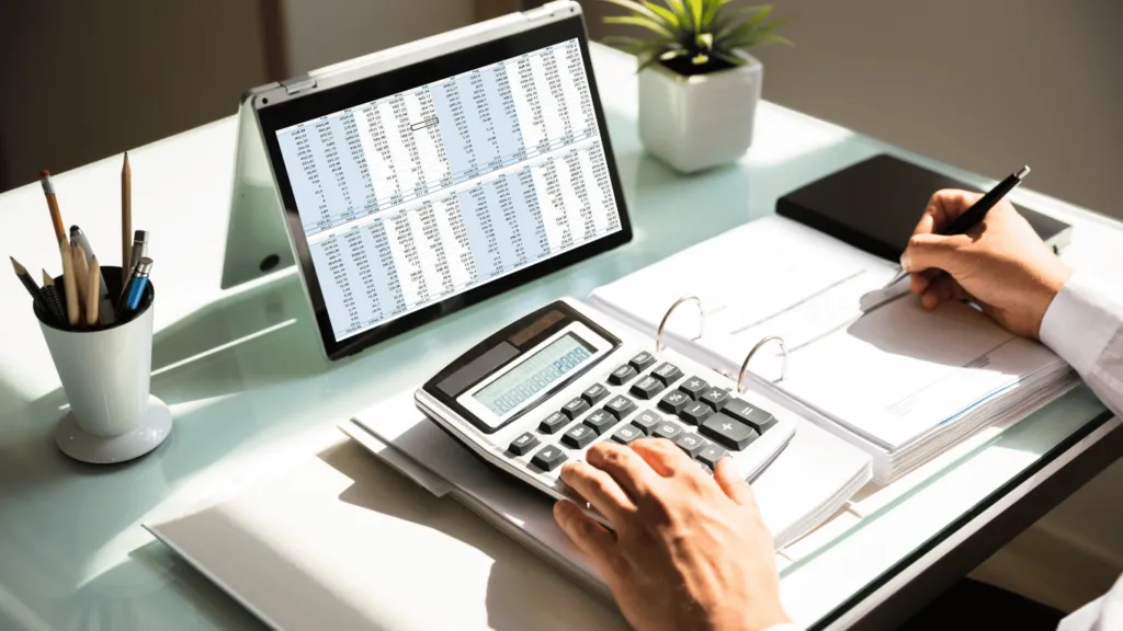 A person using a calculator while reviewing a monthly expense sheet, demonstrating how tracking expenses is crucial for maintaining an Effective Budget.