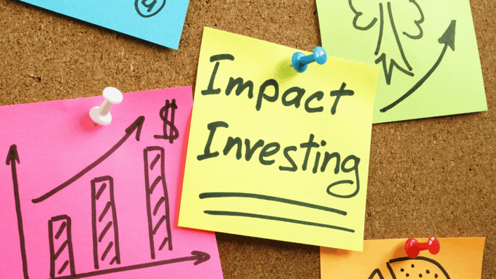 Notas adhesivas de colores en un tablero de corcho con el texto "Impact Investing", gráficos y flechas de crecimiento, ilustrando la planificación estratégica de la inversión de impacto.