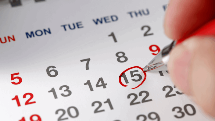 Una hoja de calendario con una fecha circulada de rojo. Simboliza los pagos automáticos que mejoran tu puntaje de crédito.