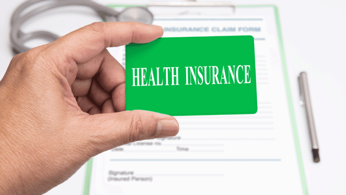 Primer plano de una tarjeta de seguro médico sobre una mesa, representando la importancia de contar con cobertura de salud.